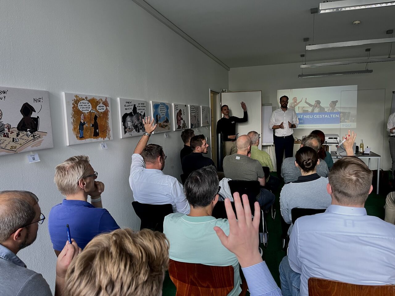 Publikum meldet sich bei der Impuls-Session 'Quality Redesigned – Thinking in AI' mit der TQU GROUP